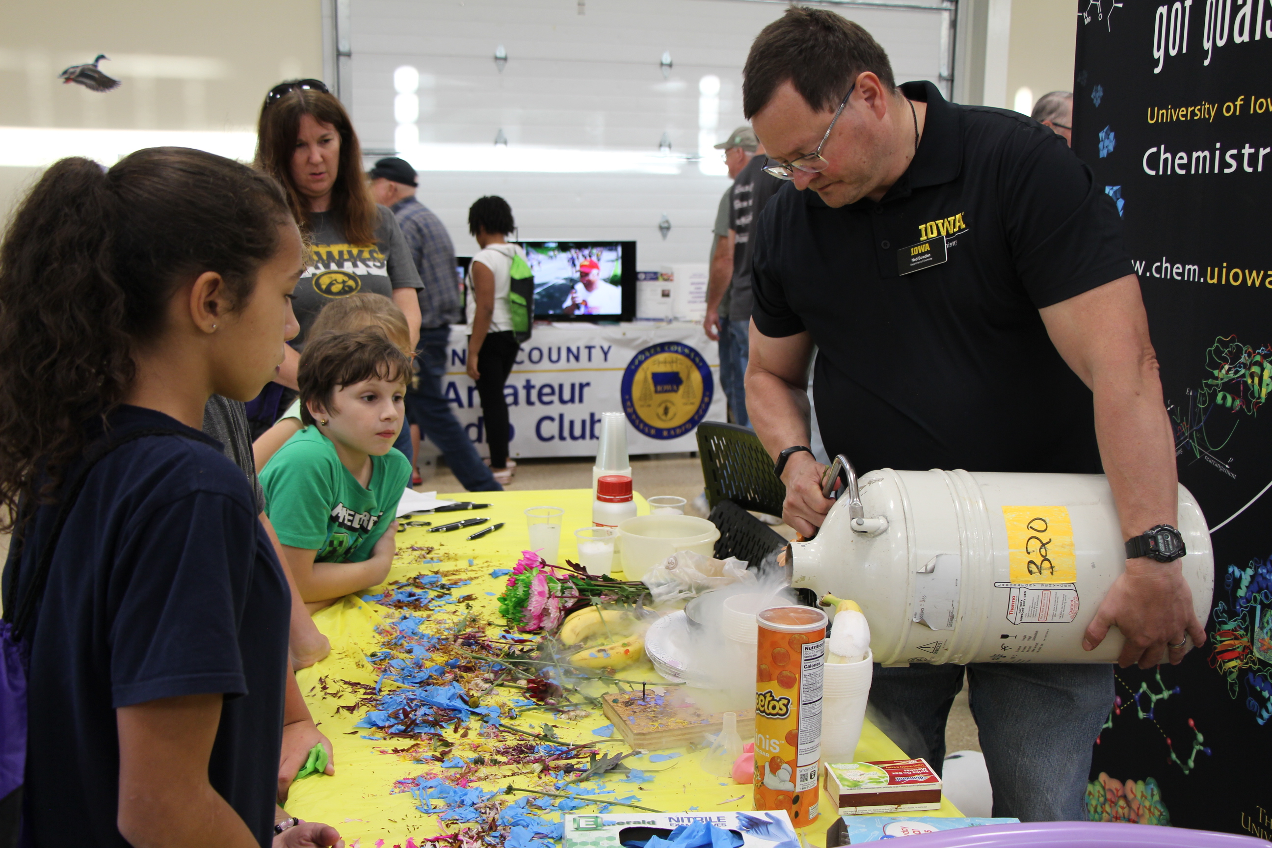 An exhibitor pours liquid nitrogen as attendees watch
